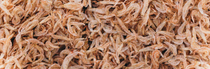 Plenty of dry shrimp background market for sell. Close-up pile texture detail bright light pink pale tone. Long, panorama format for crop banner