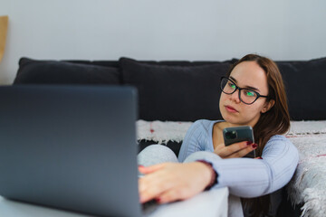 A young girl is studying or doing business from home on her laptop