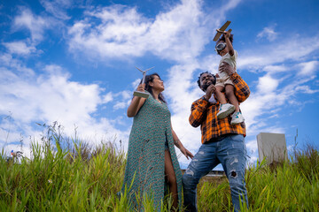 Happy African American family standing on top of a mountain and looking at the landscape on vacation and escape to nature.