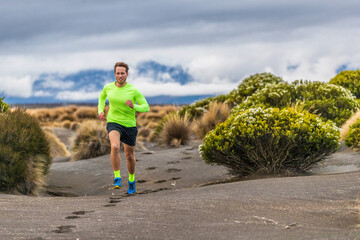 Fototapeta premium Trail run man athlete runner running marathon in desert landscape mountain hills summer background. Fitness and sports lifestyle.