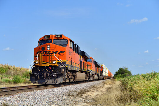 A Burlington Northern Santa Fe intermodal freight train moving at high speed through a rural stretch of  Illinois on a mainline that connects Chicago with the Twin Cities of Minneapolis and St. Paul.