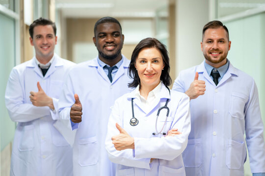 Group Of Happy multicultural doctors showing thumbs up and smiling. Portrait of multiracial medical specialists in white lab coats.
