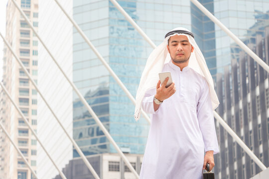 Arab businessman in the modern city, Young Saudi skilled professional engineer using smartphone