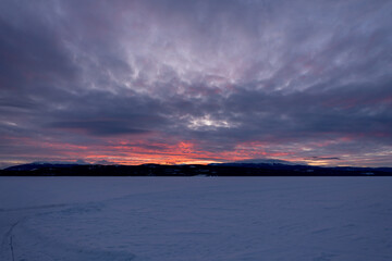 Incredible sunset views in winter season from northern Canada with bright pink clouds, mountains and snow at dusk.