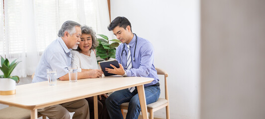Doctor using digital tablet discussing test result and diagnosis to senior couple