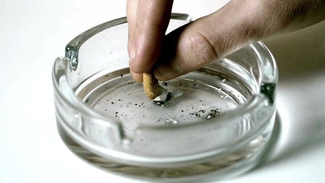 Cigarette burning in Ashtray Filled With Cigarette Butts closeup shot lifestyle healthy concept