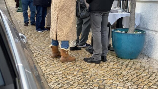 Queue of people waiting in line to be served. The queue of people standing in the cash. Could be a post office, bank or ticket sales agent