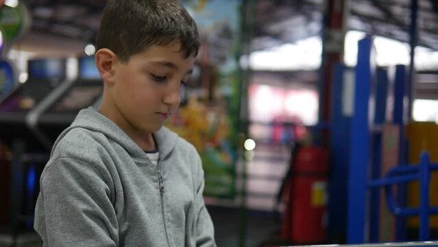 A young boy has fun playing midway games at an arcade.