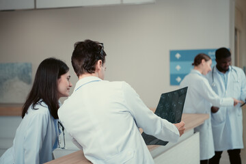 Medical teacher and interns analyzing the x-ray results of the patient's brain. before major surgery in the operating room