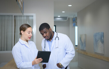 Fototapeta premium Both of doctors are analyzing the patient's MRI results on tablet to share ideas and discover new information for the patient's benefit in their treatment.