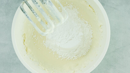 Cream cheese whipped cream recipe. Mixing cream cheese, sugar powder, and whipping cream together in a bowl. Close-up preparation process, recipe