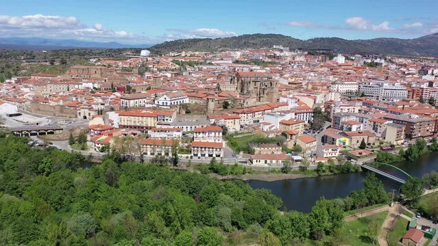 Bird's eye view of residential buildings with tiled roofs, Jerte River and cathedral in Plasencia, Extremadura, Spain. 