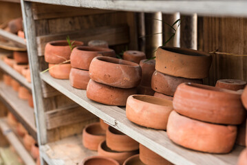 Small terracotta shallow planter pots for succulents plants for sale at a garden store. - obrazy, fototapety, plakaty