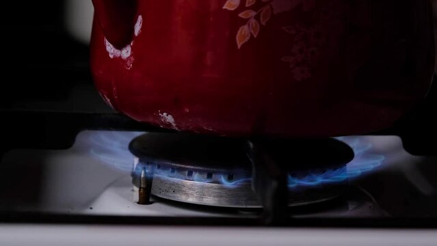 Ignition of the gas burner on the stove in the kitchen. Use of natural resources, economy, cooking on fire. Close-up