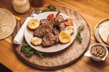 Lamp Rack Steak or Lamb chops Steak with rosemary, onion and tomato on wooden background.
