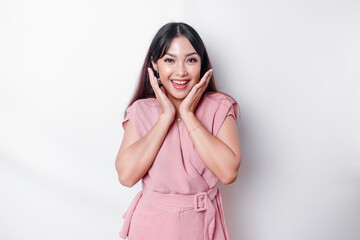 A portrait of a cute Asian woman dressed in pink, and feeling excited and isolated by a white background