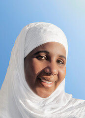 Portrait of a woman wearing a a white religious veil, 35 years old, outdoors, blue sky, sunny day,...