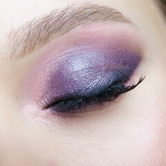 Obraz premium Closeup macro shot of human female eye. Woman with lilac beauty eyes makeup.