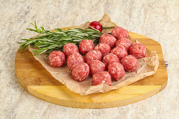 Raw uncooked beef meatballs served rosemary