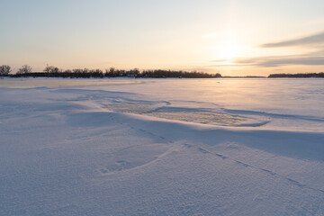 Winter sunset on the big river, hummocks in the rays of the sun.