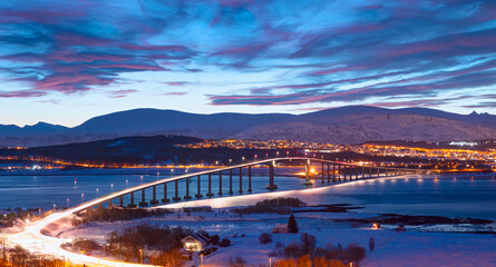 Fototapeta premium Urban landscape of Tromso in Northern Norway with full moon - Arctic city of Tromso with Sandnessundet bridge -Tromso, Norway 