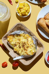 kebabs on skewers spring rolls and corn