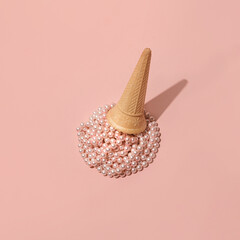 Pastel pink pearl beads and ice cream cone, creative summer fashion inspired aesthetic layout against dusty rose background. 