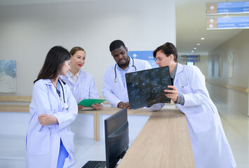 Medical teacher and interns analyzing the x-ray results of the patient's brain. before major surgery in the operating room