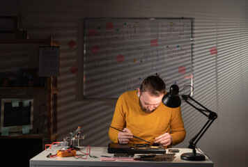 Repairman working in technical support fixing computer laptop, cleaning dirt with brush