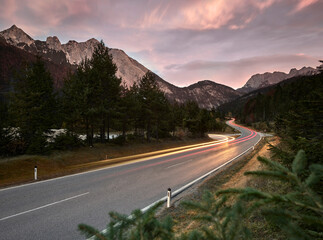 Austria, Vehicle light trails stretching along country road at dusk