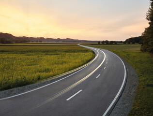 Austria, Vehicle light trails stretching along country road at dusk
