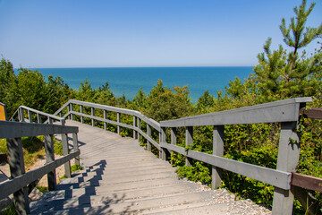 wooden walking path and stairs by the sea in Jastrzebia Góra Poland on a warm summer holiday day