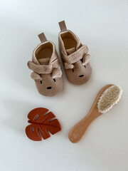 children's brown shoes with a muzzle and ears, a sheet of monsters and a baby hair brush on a white background. view from above. flatley. copy space