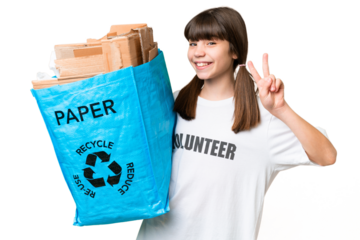 Little Caucasian girl holding a recycling bag full of paper to recycle over isolated background smiling and showing victory sign