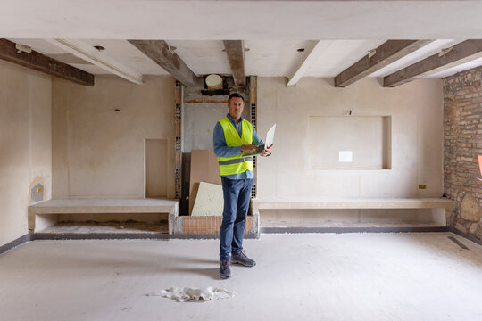 Contractor With Laptop Standing At Construction Site