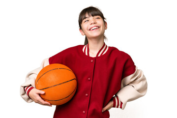 Little caucasian girl playing basketball over isolated background posing with arms at hip and...