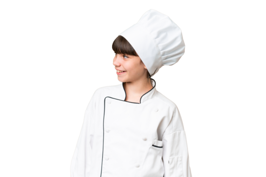 Little caucasian chef girl over isolated background looking side