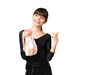 Little caucasian girl practicing ballet over isolated background pointing to the side to present a...