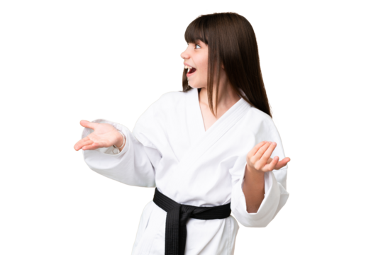 Little Caucasian girl doing karate over isolated background with surprise facial expression