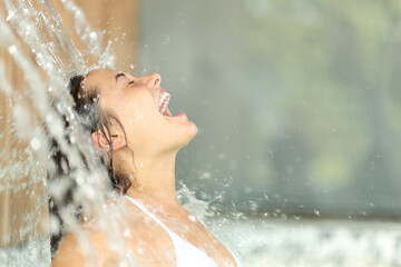 Woman screaming under water jet in spa