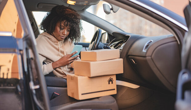 Young Woman Using Smart Phone In Car