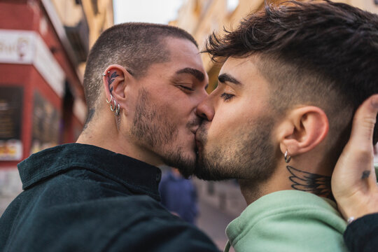 Romantic gay couple kissing outside building