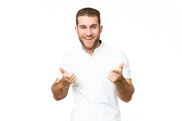 Young handsome blonde man over isolated chroma key background pointing to the front and smiling