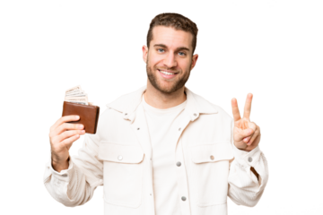 Young handsome blonde man holding a wallet over isolated chroma key background smiling and showing victory sign