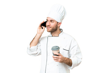 Young blonde man Chef over isolated chroma key background holding coffee to take away and a mobile
