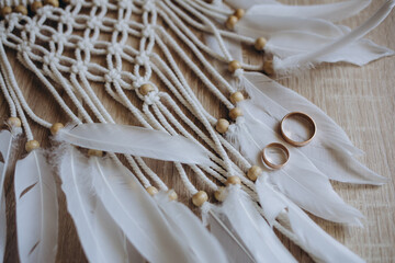 Wedding rings on a wooden box with shadows of leaves