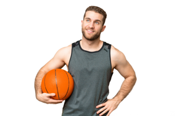 Handsome young man playing basketball over isolated chroma key background posing with arms at hip and smiling