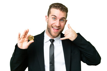Young business blonde man holding a Bitcoin over isolated chroma key background making phone gesture. Call me back sign