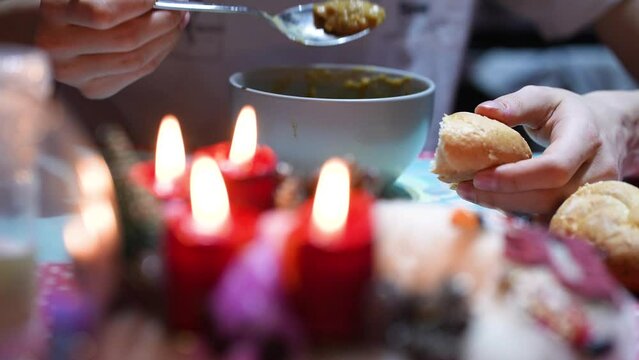 Eating bread and a bowl of meal with christmas candles