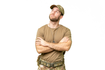 Military with dog tag over isolated chroma key background looking up while smiling